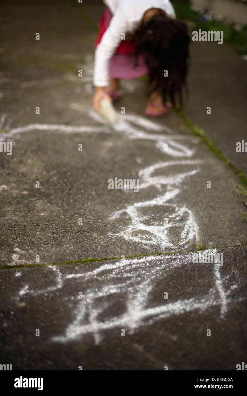 Eleanor schreibt ihr, dass fünf Jahre altes Mädchen namens Bimsstein vulkanischen Gestein wird auf betonierten Weg gezeichnet Stockfoto