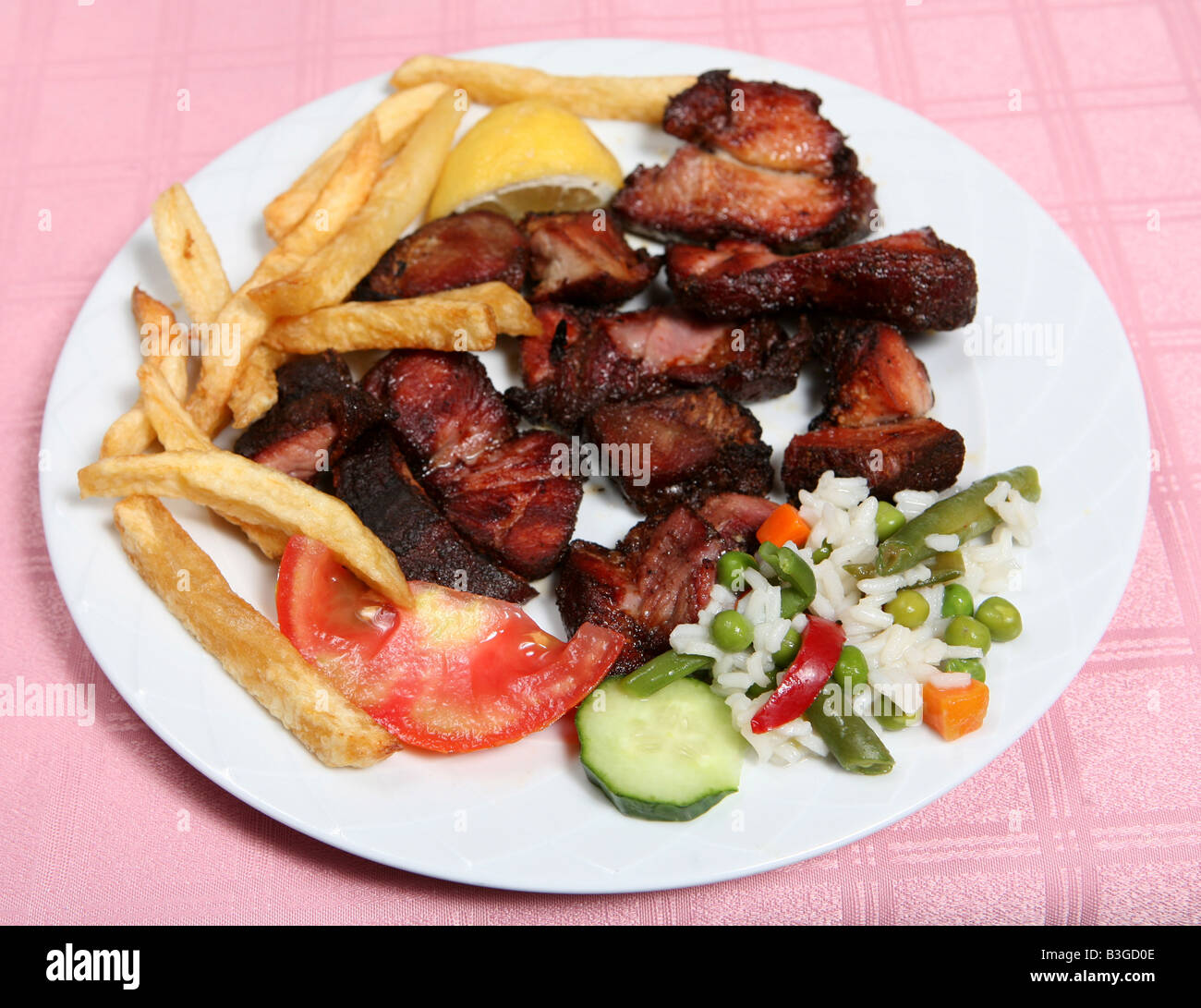 Traditionellen kretischen Apaki geräucherte Schweinefleisch mit französischen gebratene Kartoffelchips Reis und Gemüse in einer Taverne auf der griechischen Insel Stockfoto