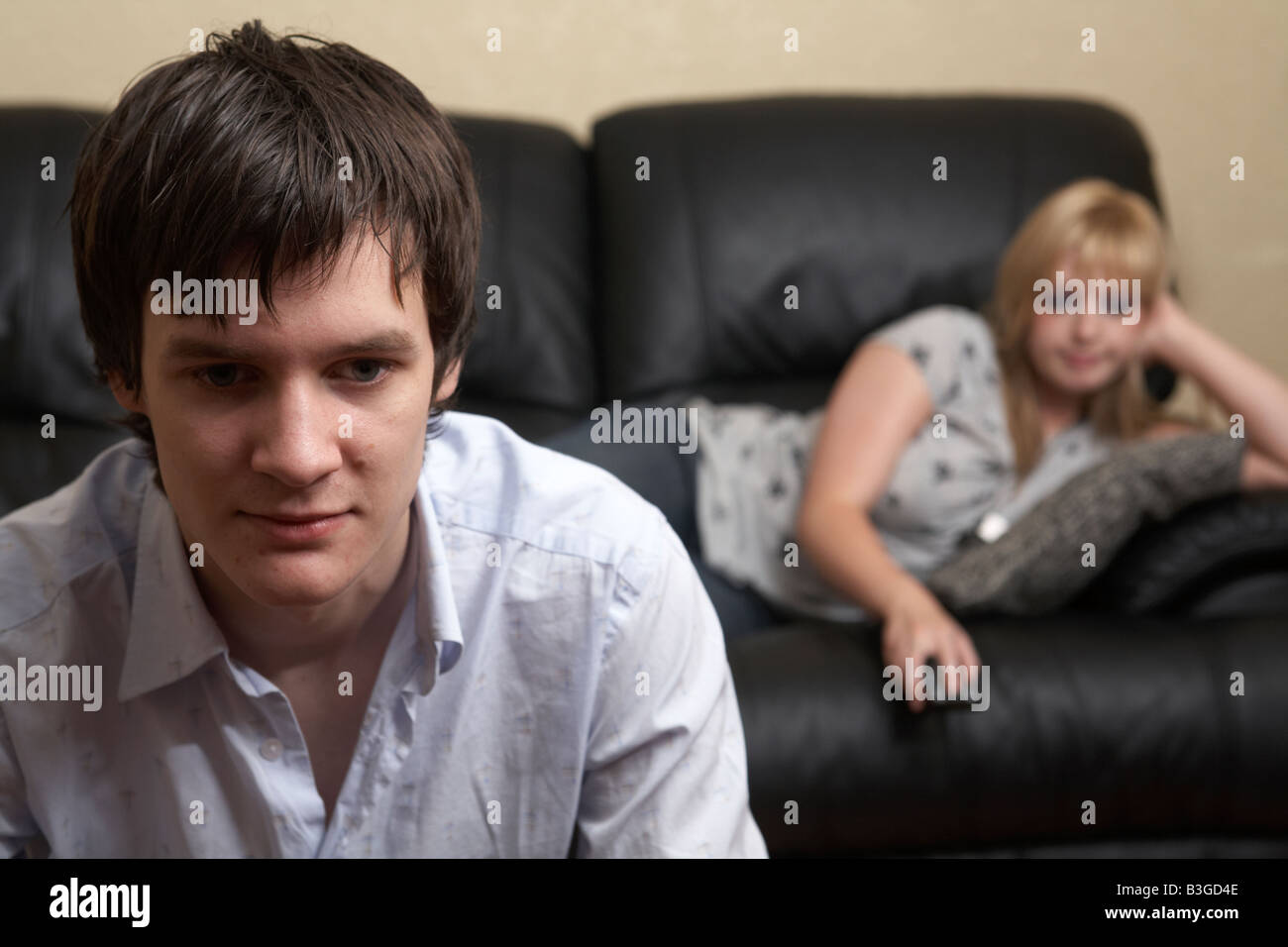 junger Mann und Frau Paar im Wohnzimmer sitzen gelangweilt mit TV-Fernbedienung Stockfoto