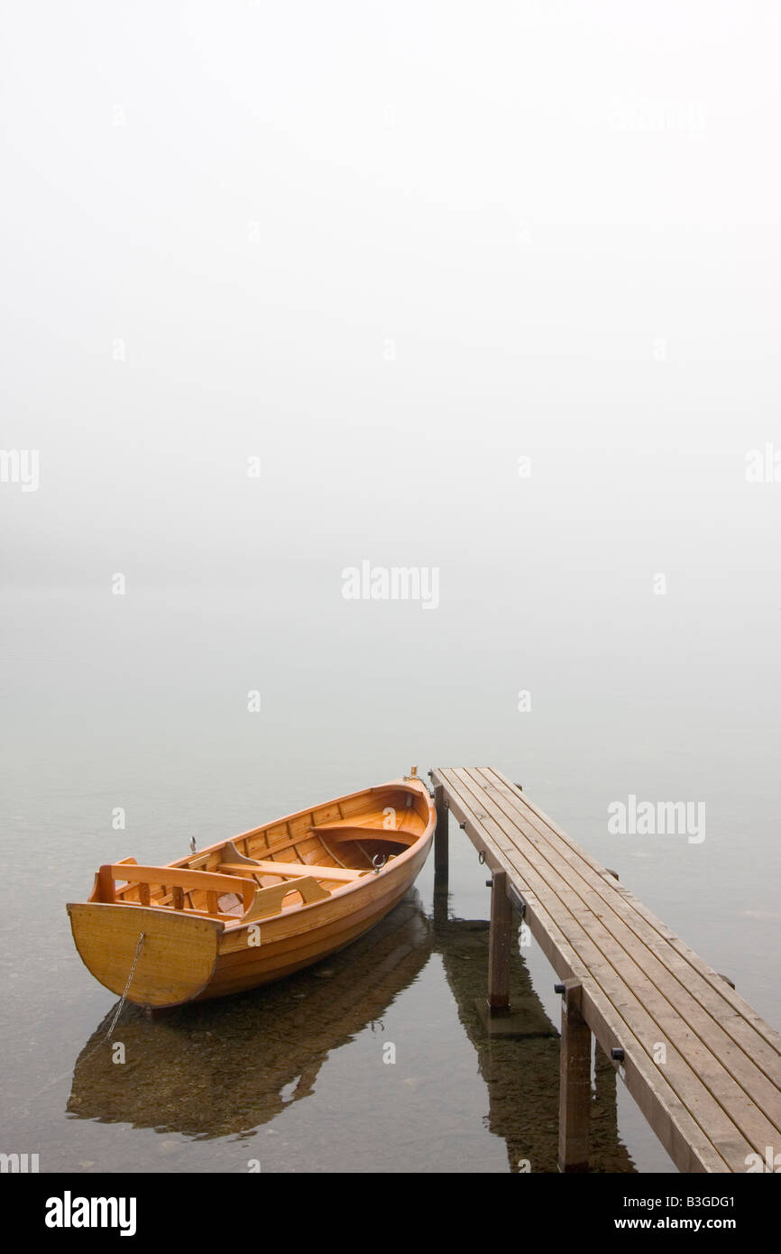 Boot an einer Anlegestelle eines Sees an einem nebligen Morgen Stockfoto