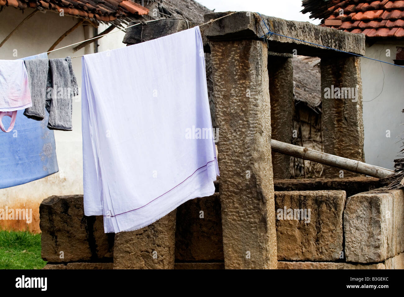 Kleidung schwebt über einem Brunnen in Karnataka Stockfoto