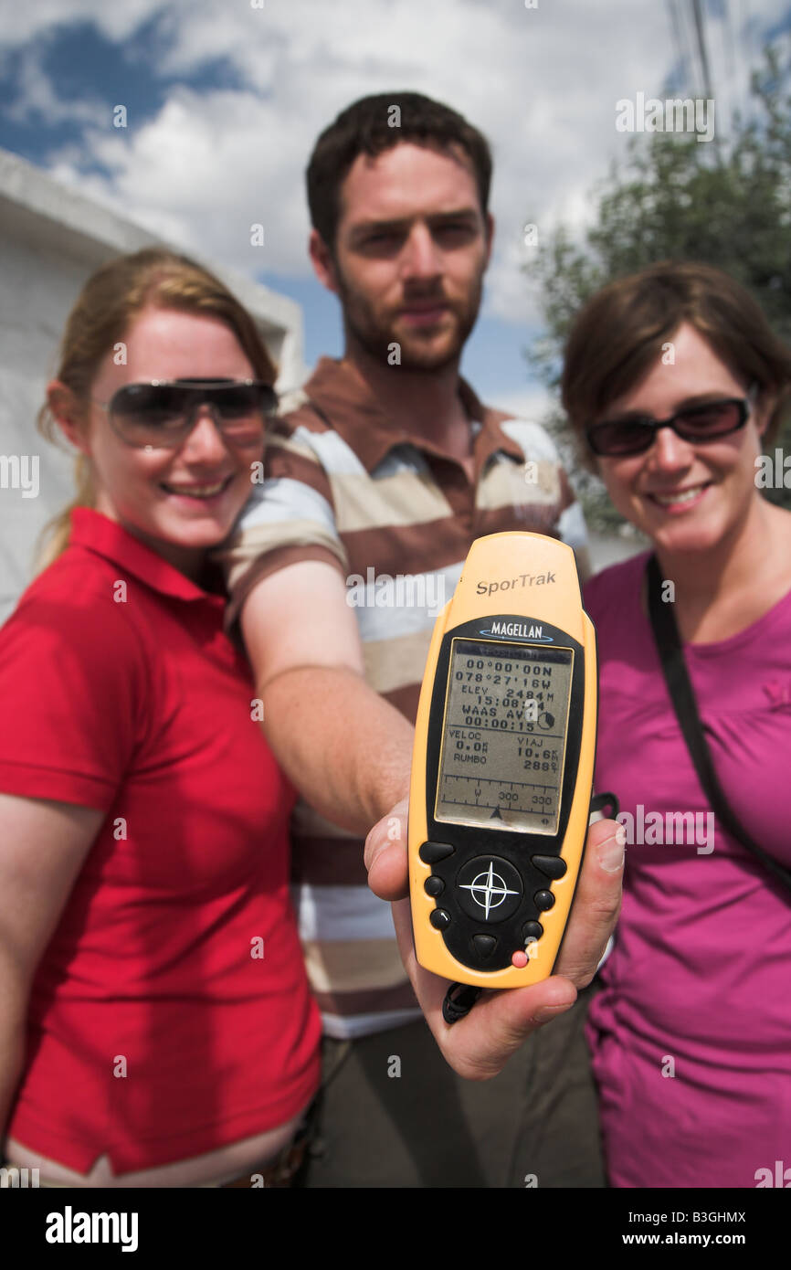 Touristen, die mit einem GPS-Gerät zeigt 00.00.00 Breitengrad auf der Mitte der Erde in der Nähe von Quito in Equador. Stockfoto