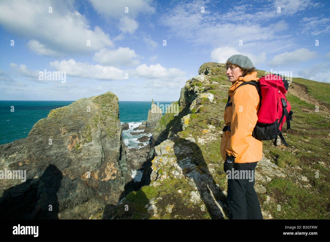Meer-Stack und Frau zu Fuß der South West Coast Path in der Nähe von Stepper Point in der Nähe von Padstow auf Cornwall UK Stockfoto