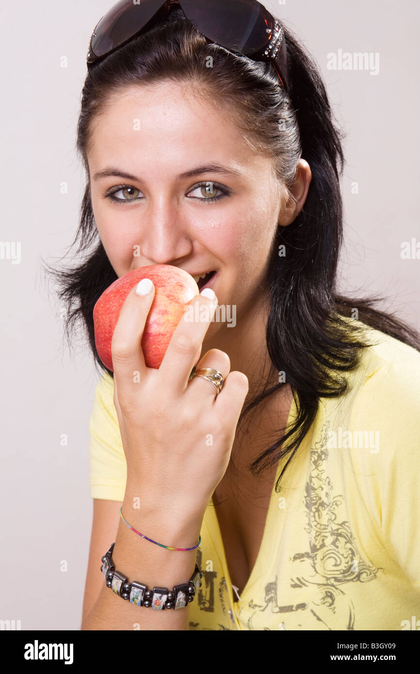 Junge fröhliche Frau einen Apfel essen Stockfoto