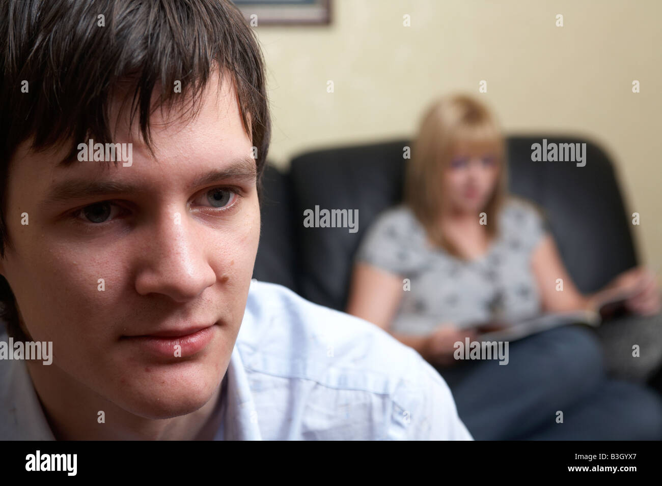 junger Mann und Frau Paar im Wohnzimmer sitzen gelangweilt Stockfoto