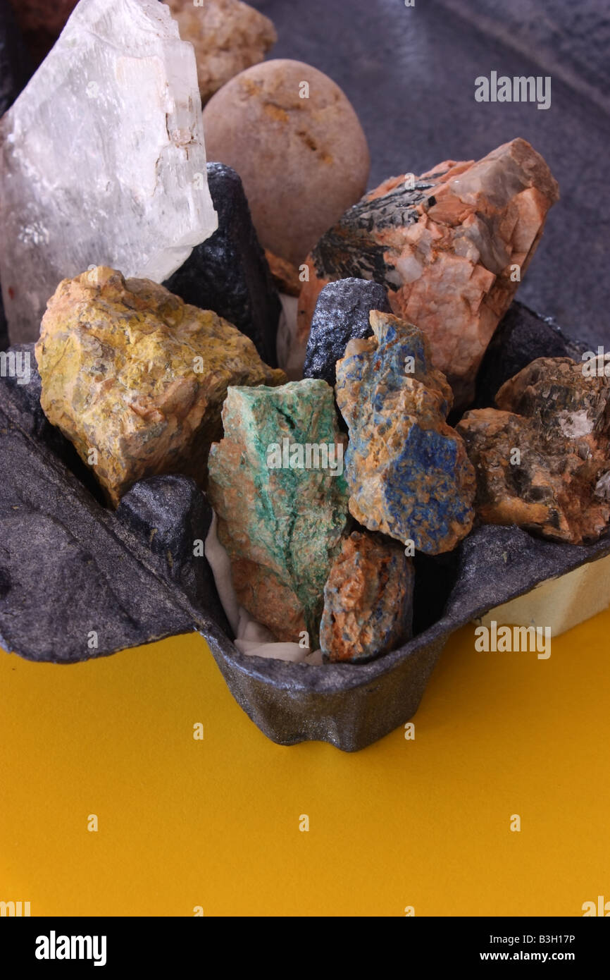 verschiedene Arten von Rohmineralien aus Australien platziert in einem gemalten Eierkarton mit einem gelben Vordergrund Stockfoto