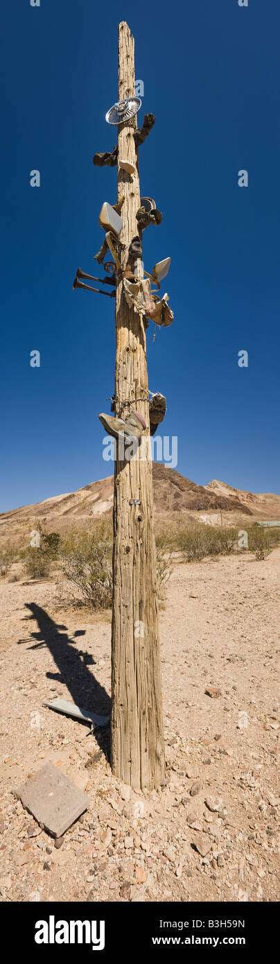 Telegrafenmast mit Kfz-Teilen und Schuhe. Rhyolith, Nevada, USA. Stockfoto
