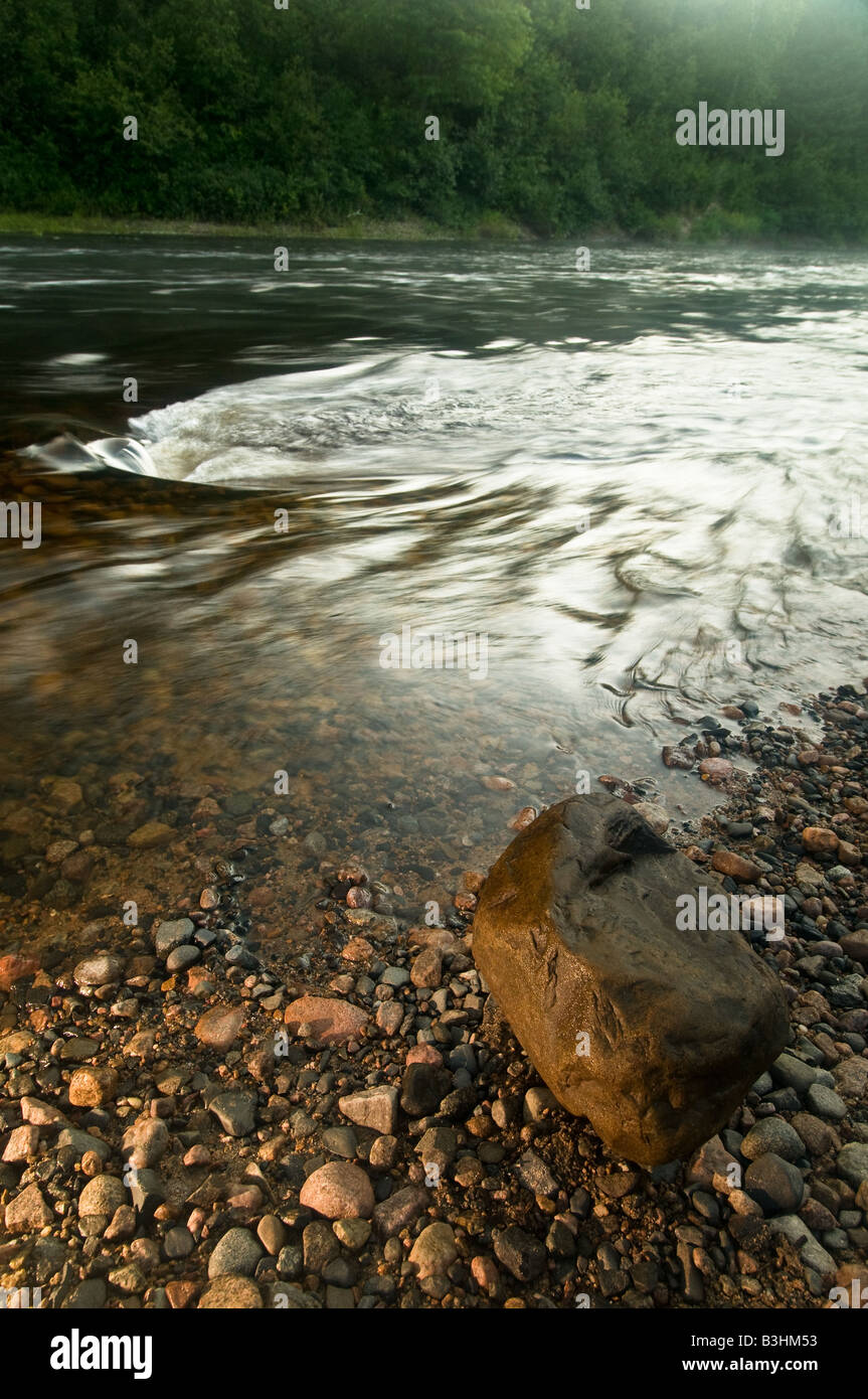 Einem großen Felsbrocken am Ufer eines schnell bewegten Flusses. Stockfoto