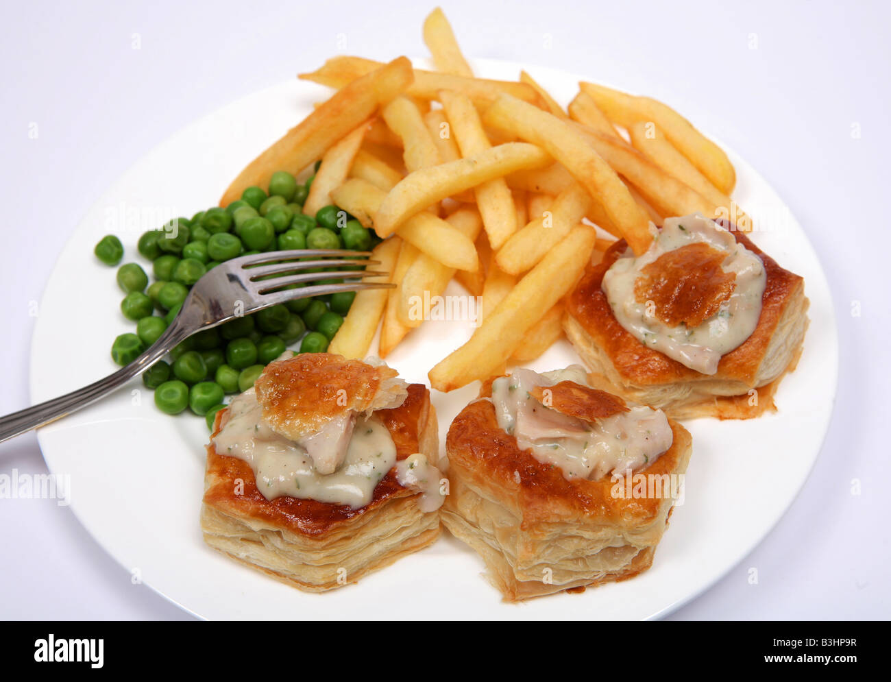 Eine köstliche Mahlzeit Türkei Sauce Vol au Vents serviert mit Erbsen gefüllt und französische gebratene Kartoffelchips Stockfoto