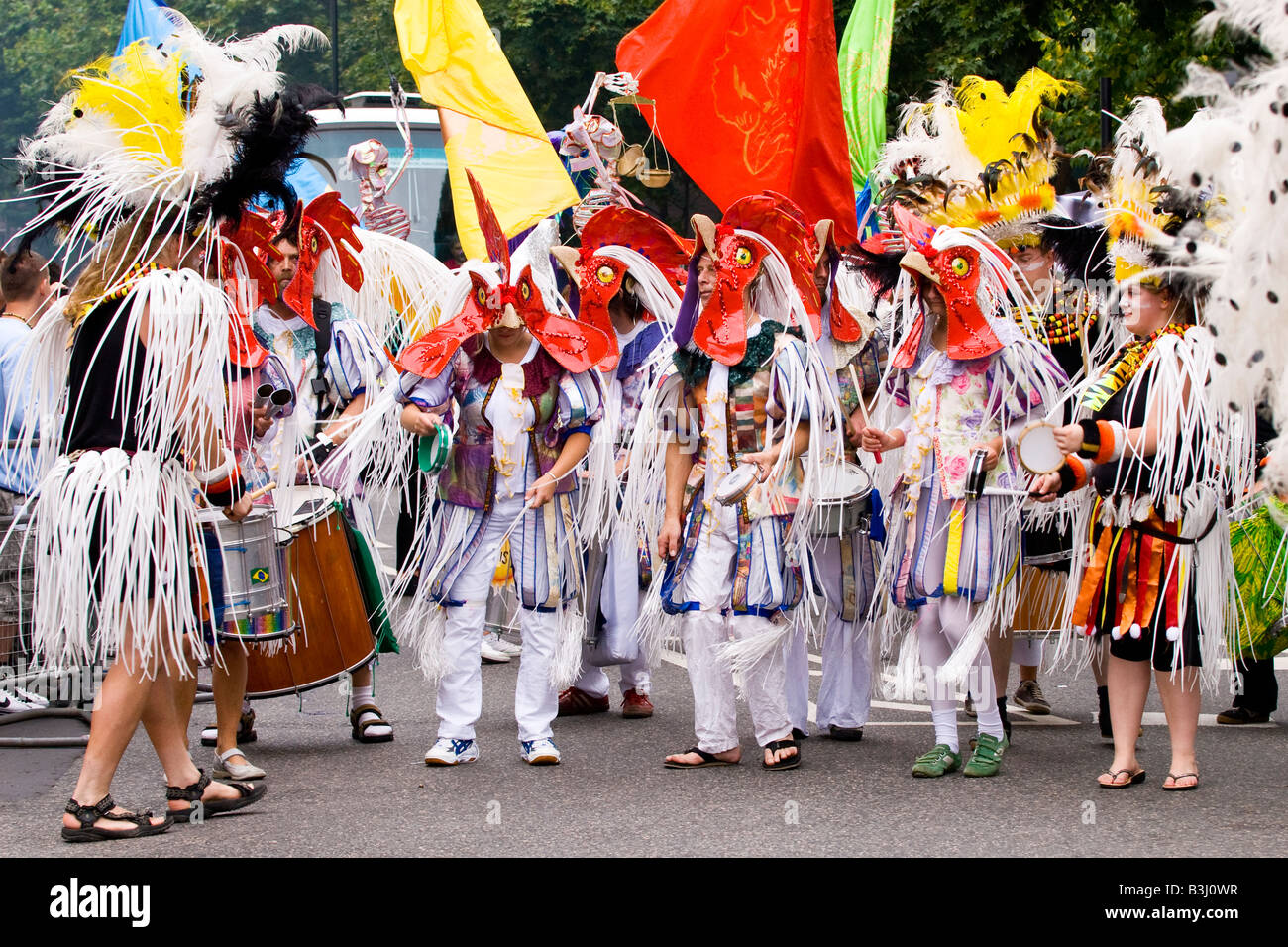 London, Notting Hill Carnival Parade, Tanzgruppe in weißen und roten Huhn Kostüme mit Trommeln und Tamburins Stockfoto
