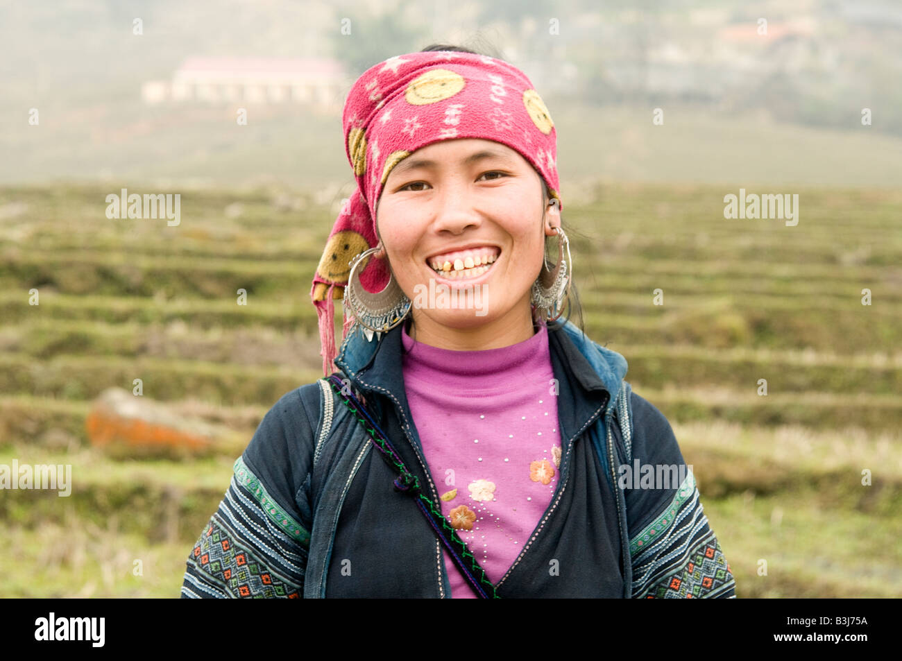 Ein Porträt eines glücklichen schwarzen Hmong-Mädchens in den Hügeln um Sapa in Nordvietnam Stockfoto
