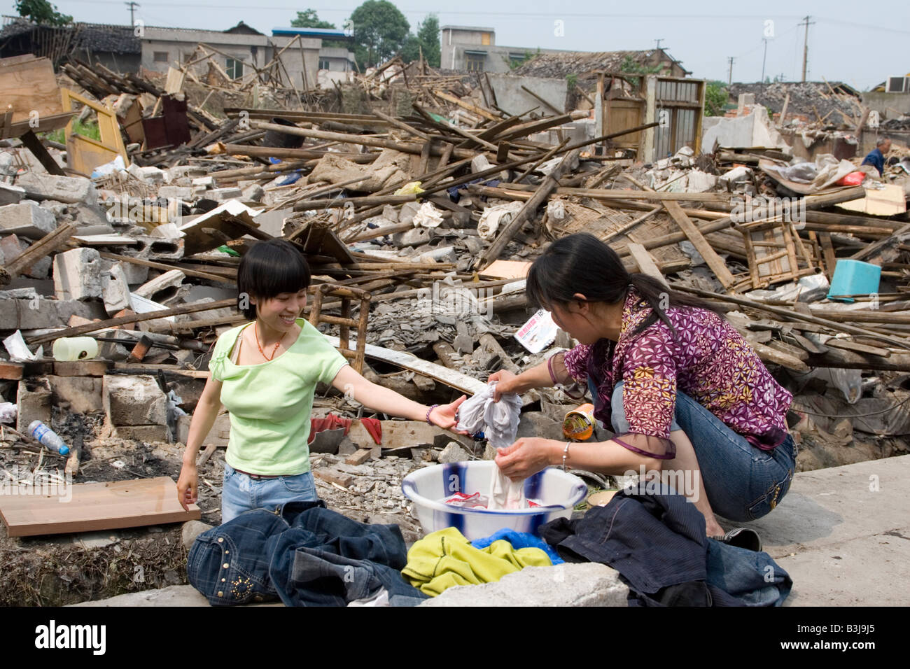 Zwei Überlebende des Erdbebens in Sichuan am 12. Mai 2008 Wäsche außerhalb ihrer zerstörten Gebäude. Stockfoto