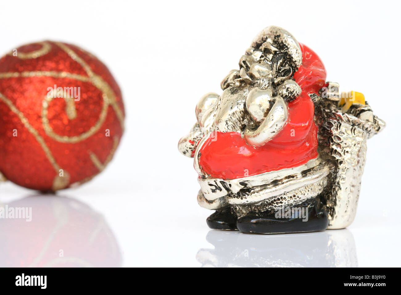 Weihnachten Symbole Silber Statue von Santa und rote Kugel isoliert Stockfoto