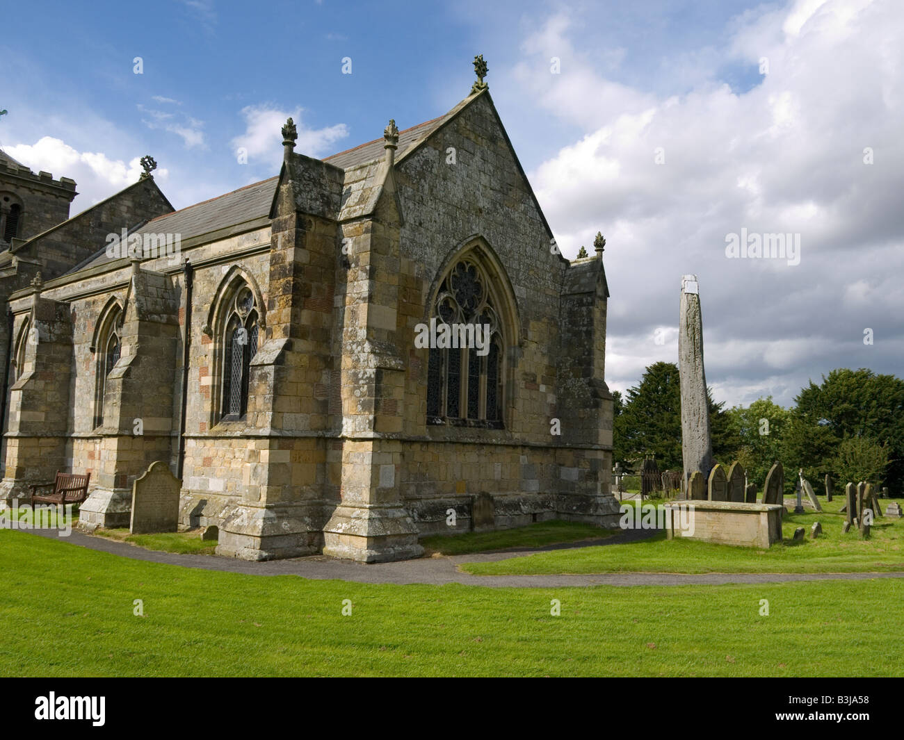 Die Kirche am Rudston East Yorkshire mit einem alten Monolith 7 6 Meter hoch auf dem Kirchhof Stockfoto