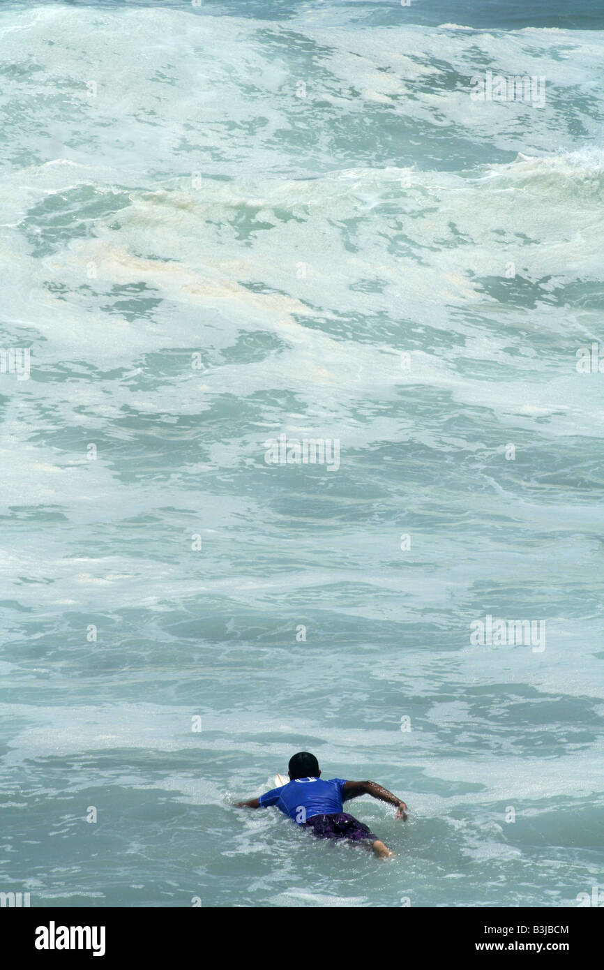 Surfer die Wellen im turbulenten Wasser paddeln Stockfoto