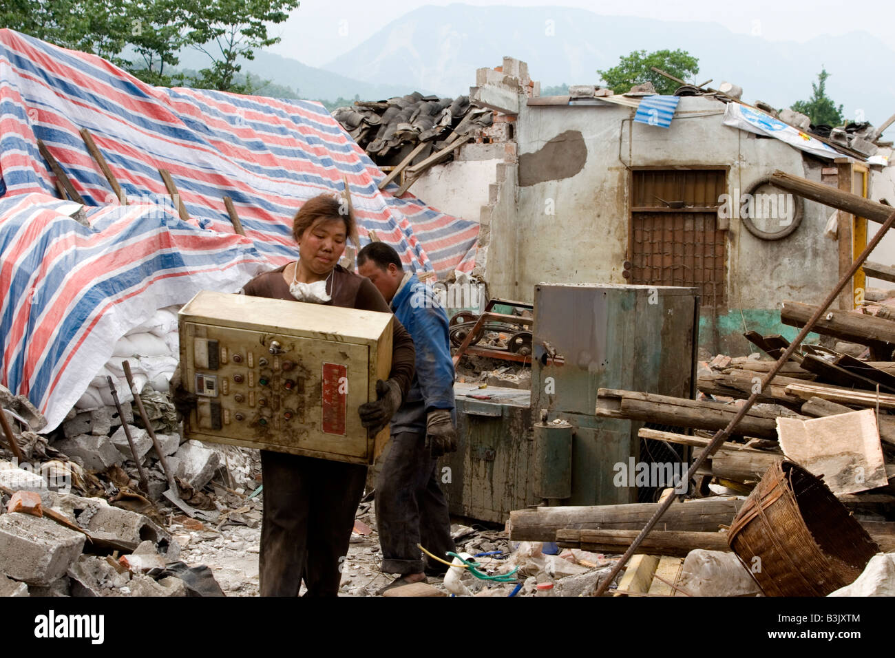 Überlebende von das massive Erdbeben Sichuan am 12. Mai 2008 abzufangen, was sie konnten, aus den Trümmern ihrer Häuser Stockfoto