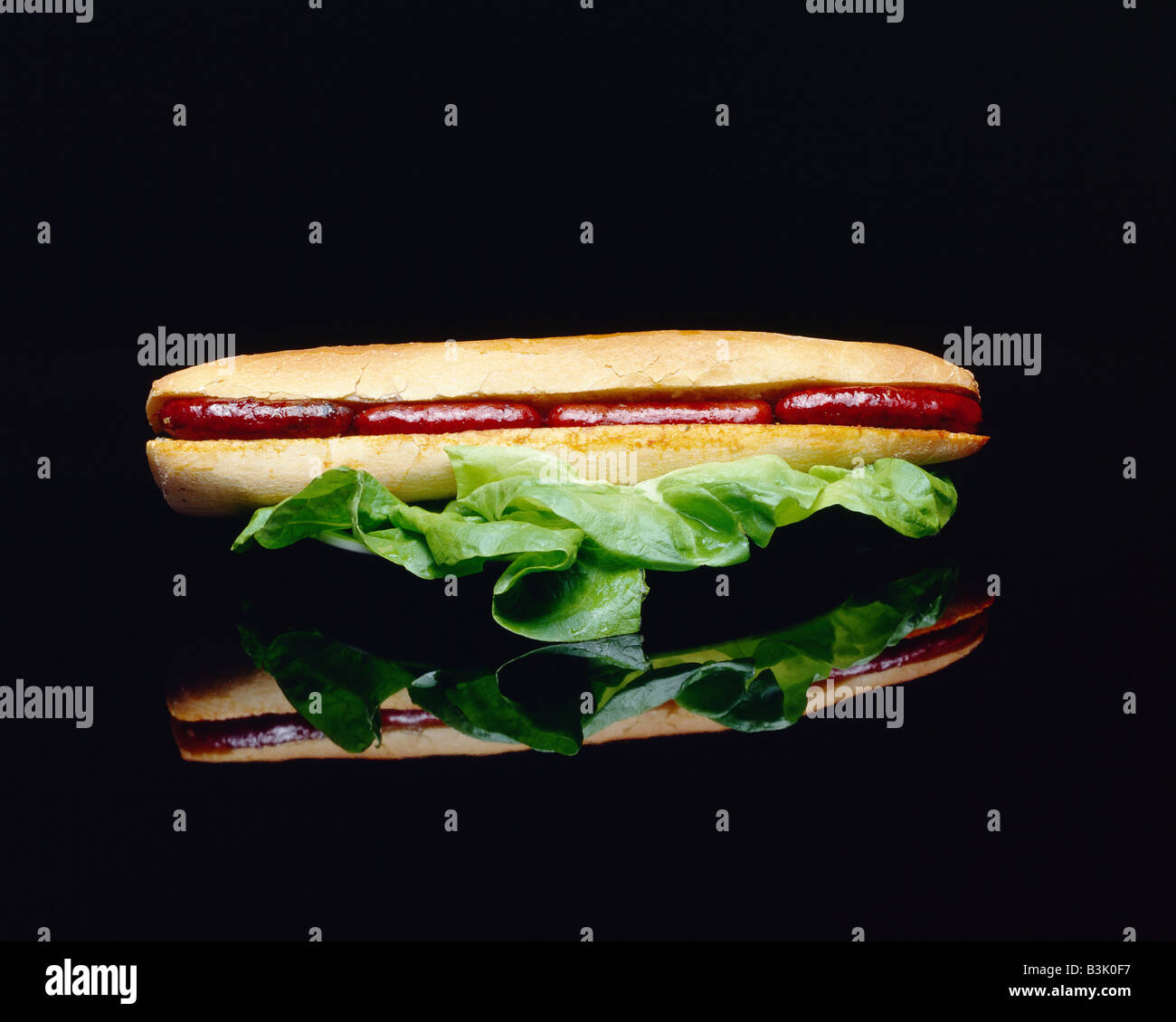 EIN SANDWICH MIT MERGUEZ WÜRSTCHEN UND SALATBLÄTTER Stockfoto