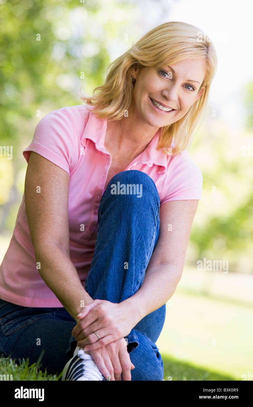 Frau sitzt im freien Lächeln Stockfoto