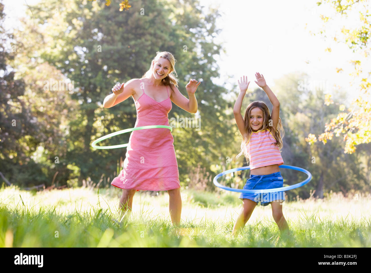 Frau und junge Mädchen mit Hula-Reifen im freien Lächeln Stockfoto