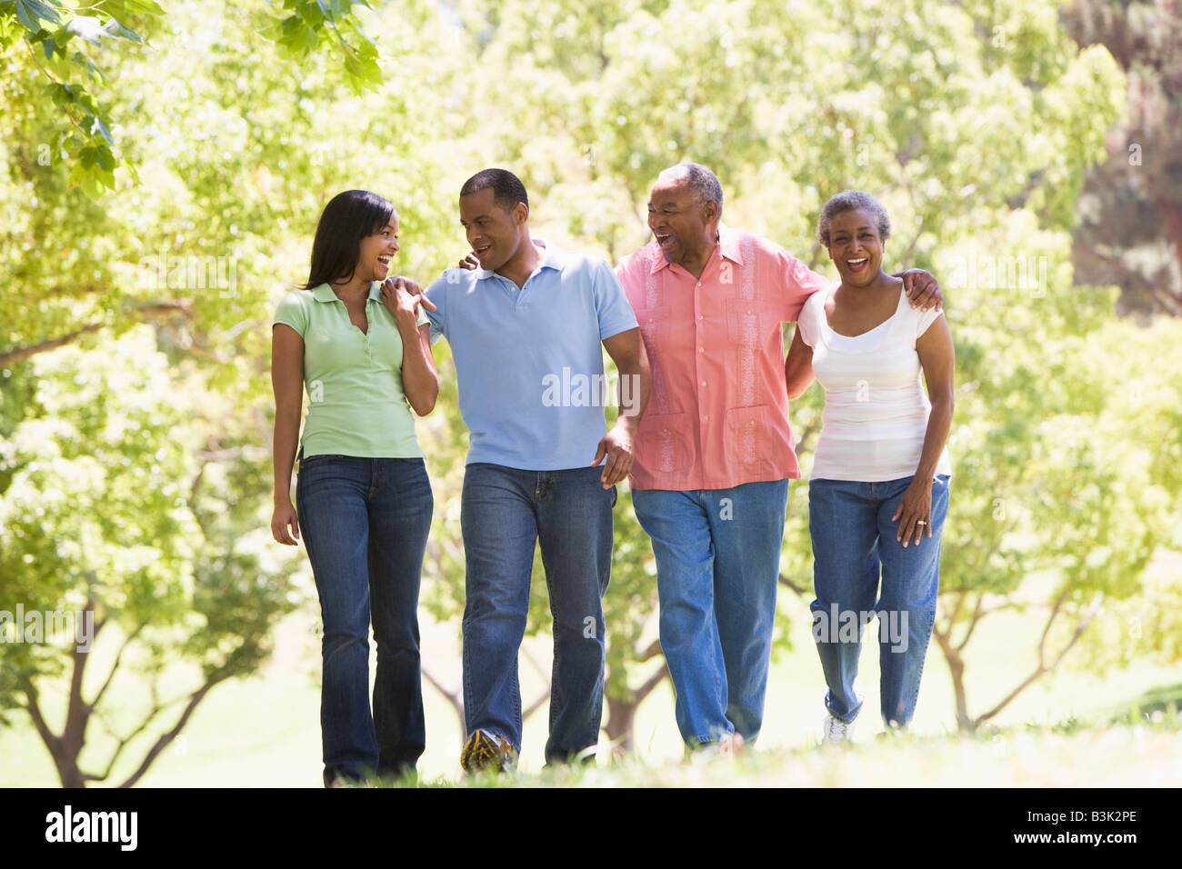 Zwei Paare im freien gehen arm in Arm zu Lächeln Stockfoto