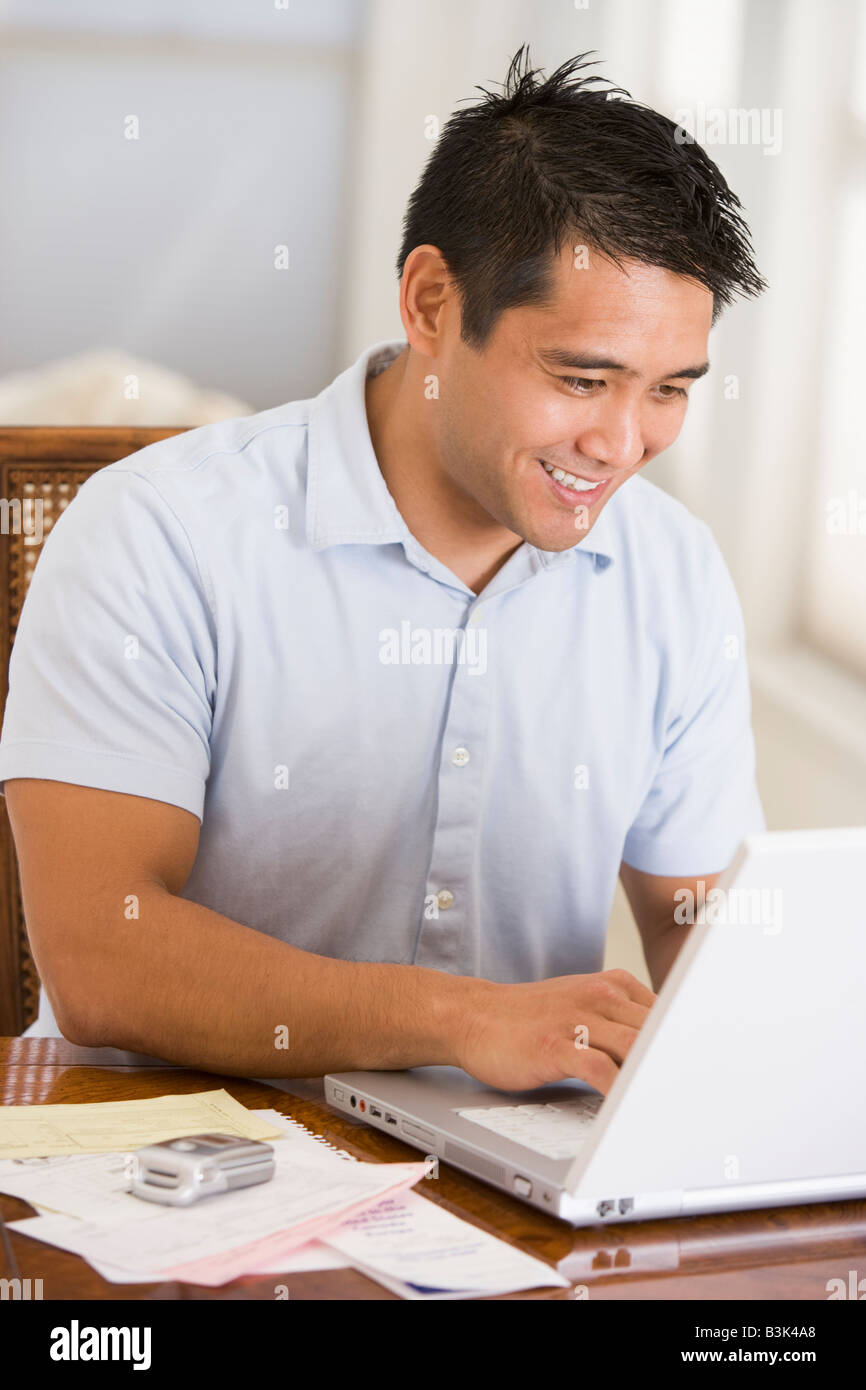 Mann im Speisesaal mit Laptop und lächelnd Stockfoto