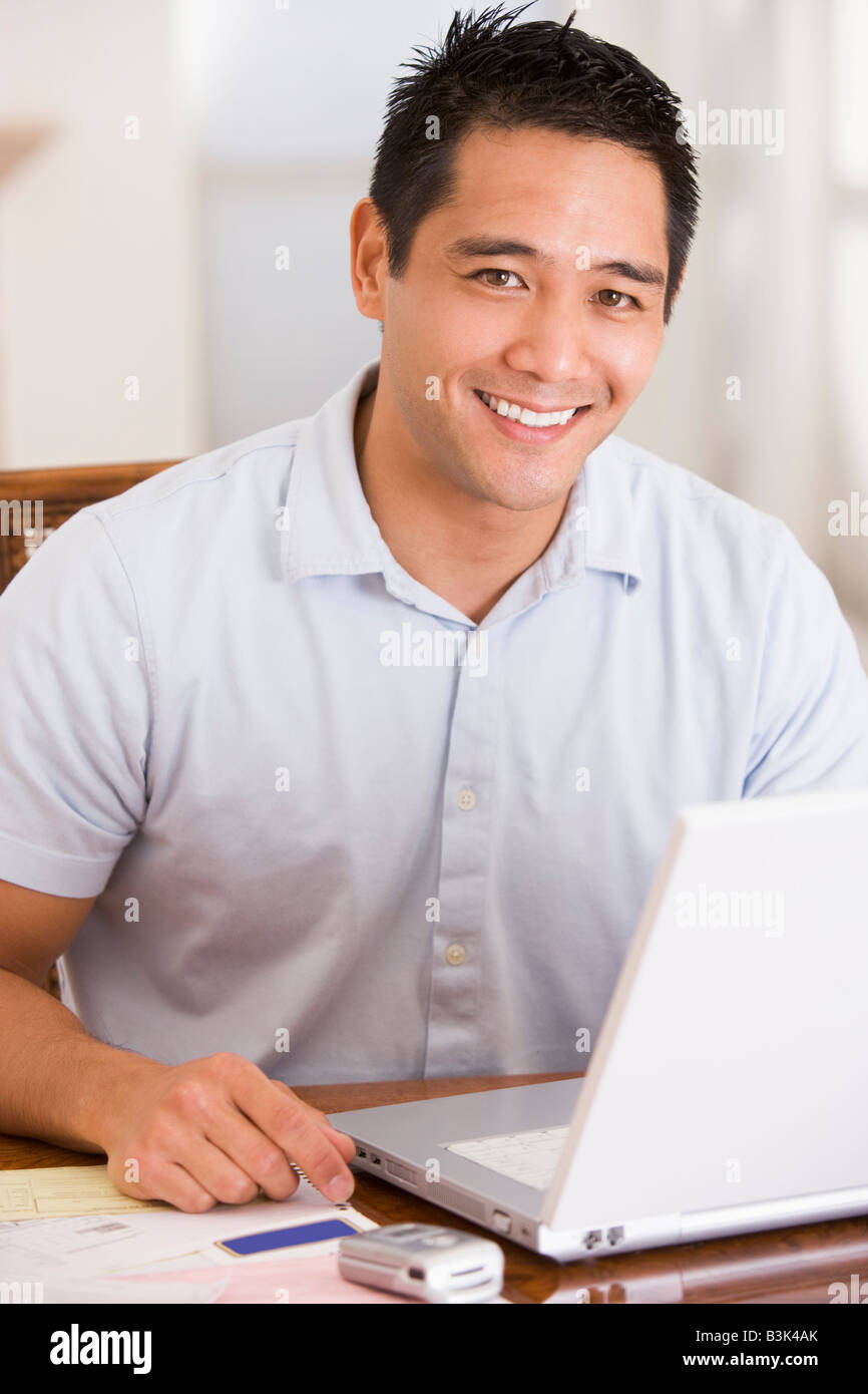 Mann im Speisesaal mit Laptop lächelnd Stockfoto