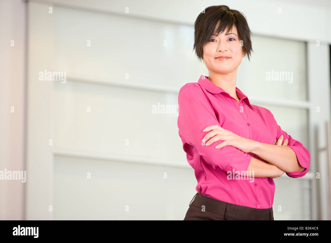 Geschäftsfrau, stehen im Innenbereich lächelnd Stockfoto