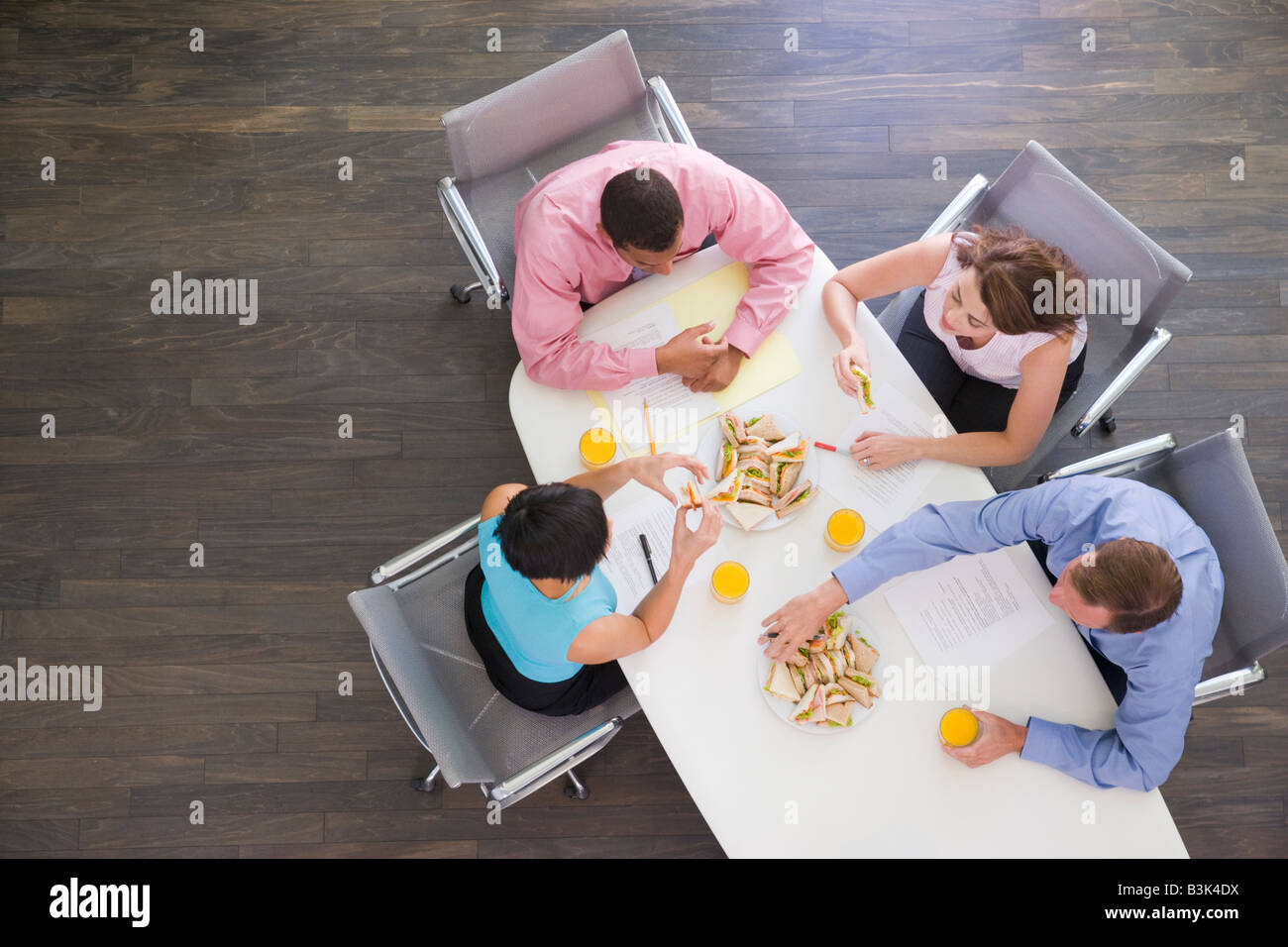 Vier Unternehmer am Konferenztisch mit sandwiches Stockfoto