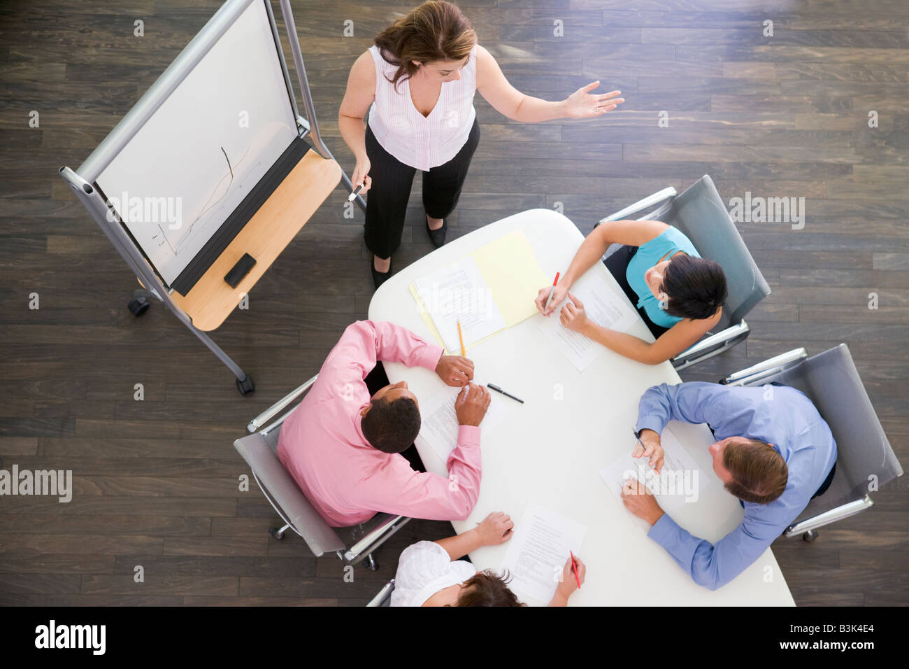 Vier Unternehmer am Konferenztisch beobachtete Präsentation Stockfoto