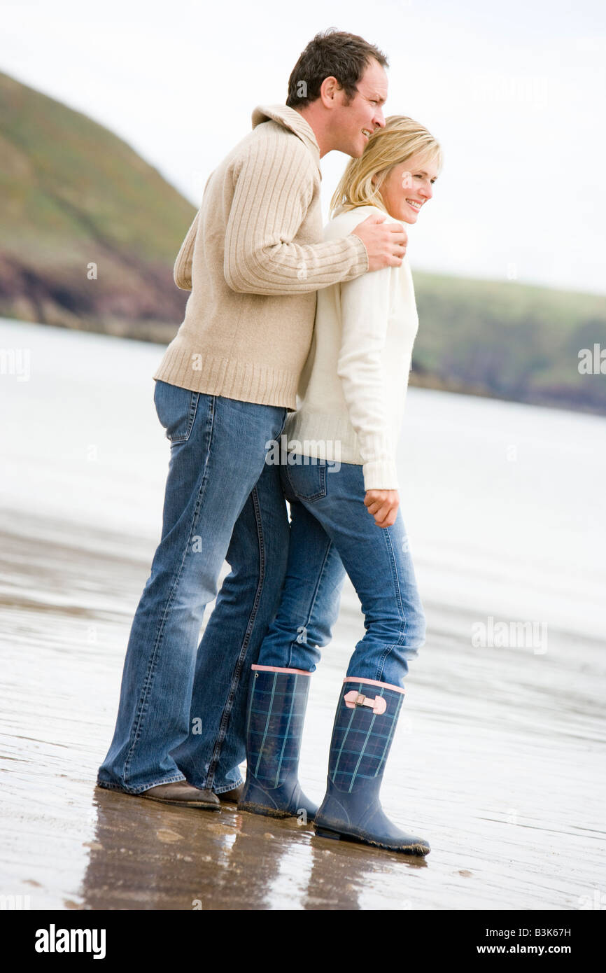 Paar steht am Strand lächelnd Stockfoto