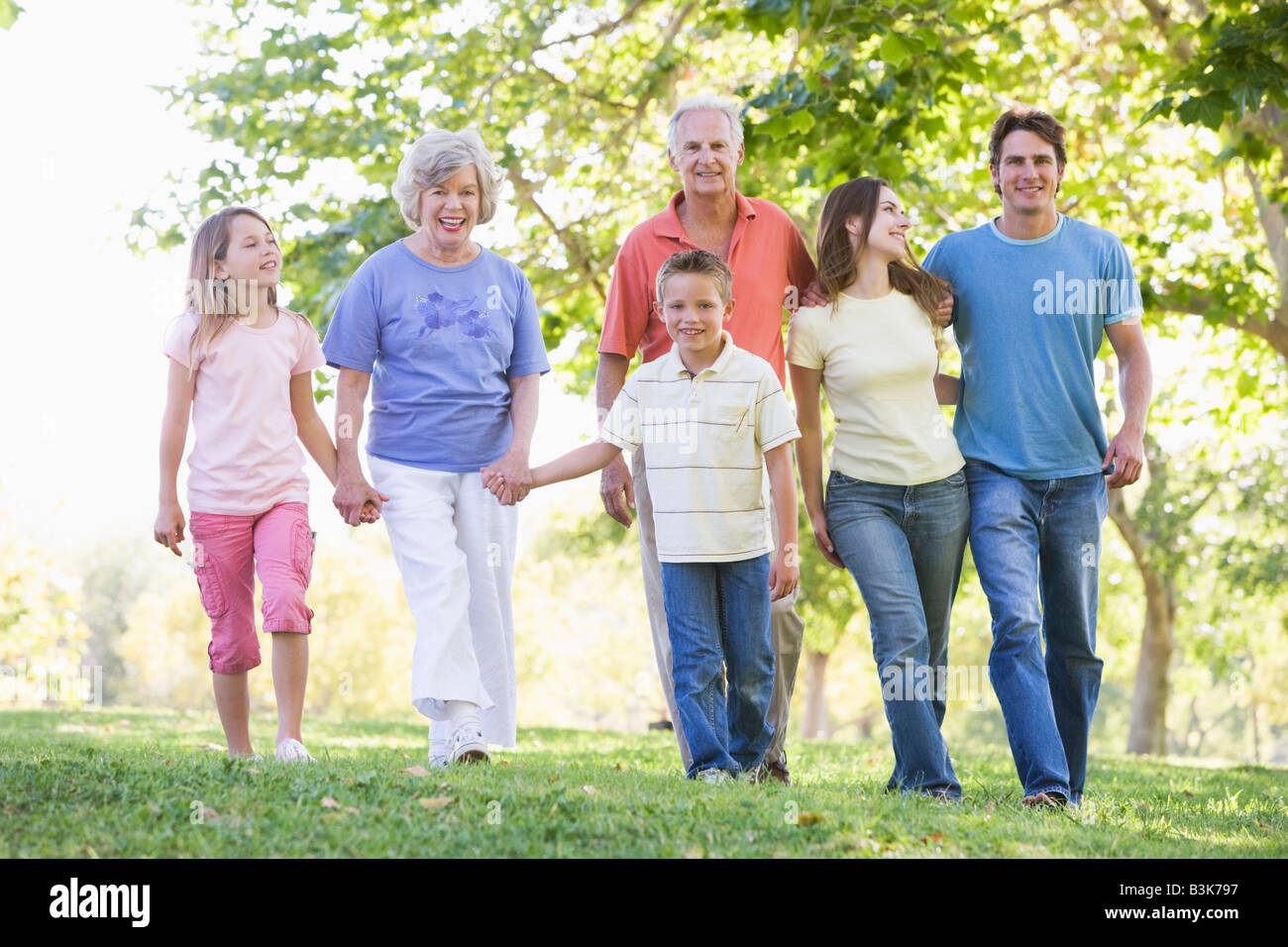 Großfamilie zu Fuß im Park Hand in Hand und lächelt Stockfoto
