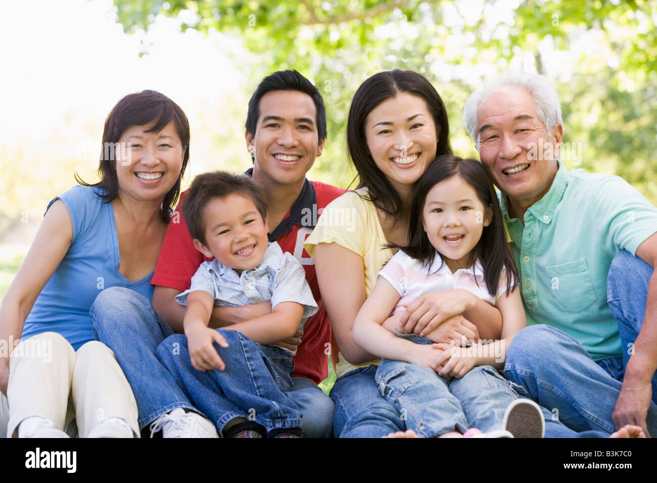 Großfamilie sitzen im freien Lächeln Stockfoto