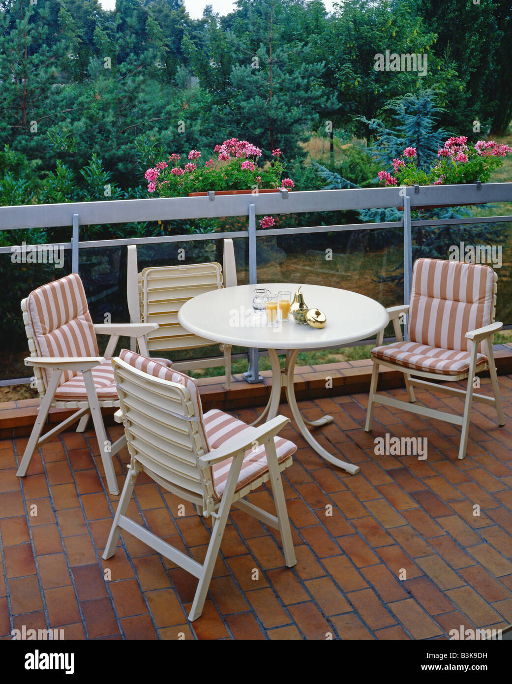 GARTENMÖBEL AUF EINER TERRASSE STÜHLE DEKORIERT MIT ROSA GESTREIFTEN STOFF Stockfoto