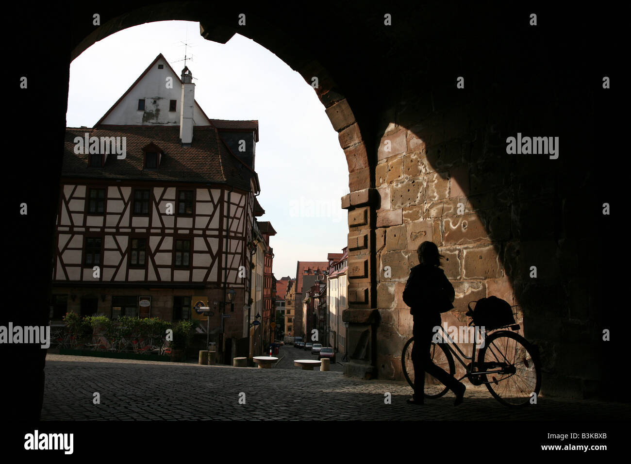 Silhouette Radfahrer zu Fuß durch das mittelalterliche Tiergartnertor Tor zum Albrecht Durer Haus in Nürnberg, Deutschland Stockfoto