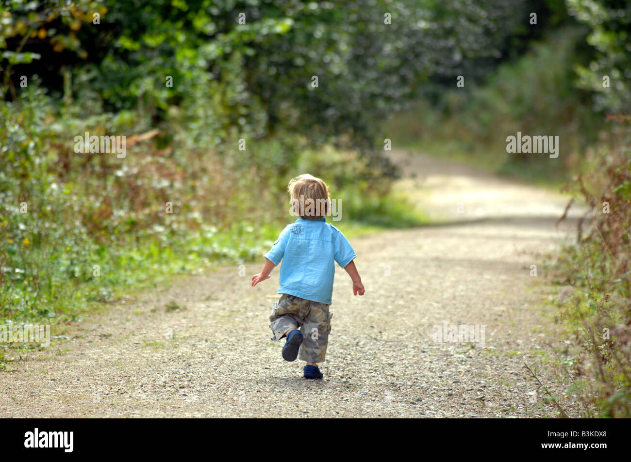 Kind läuft allein auf einem Feldweg Stockfoto