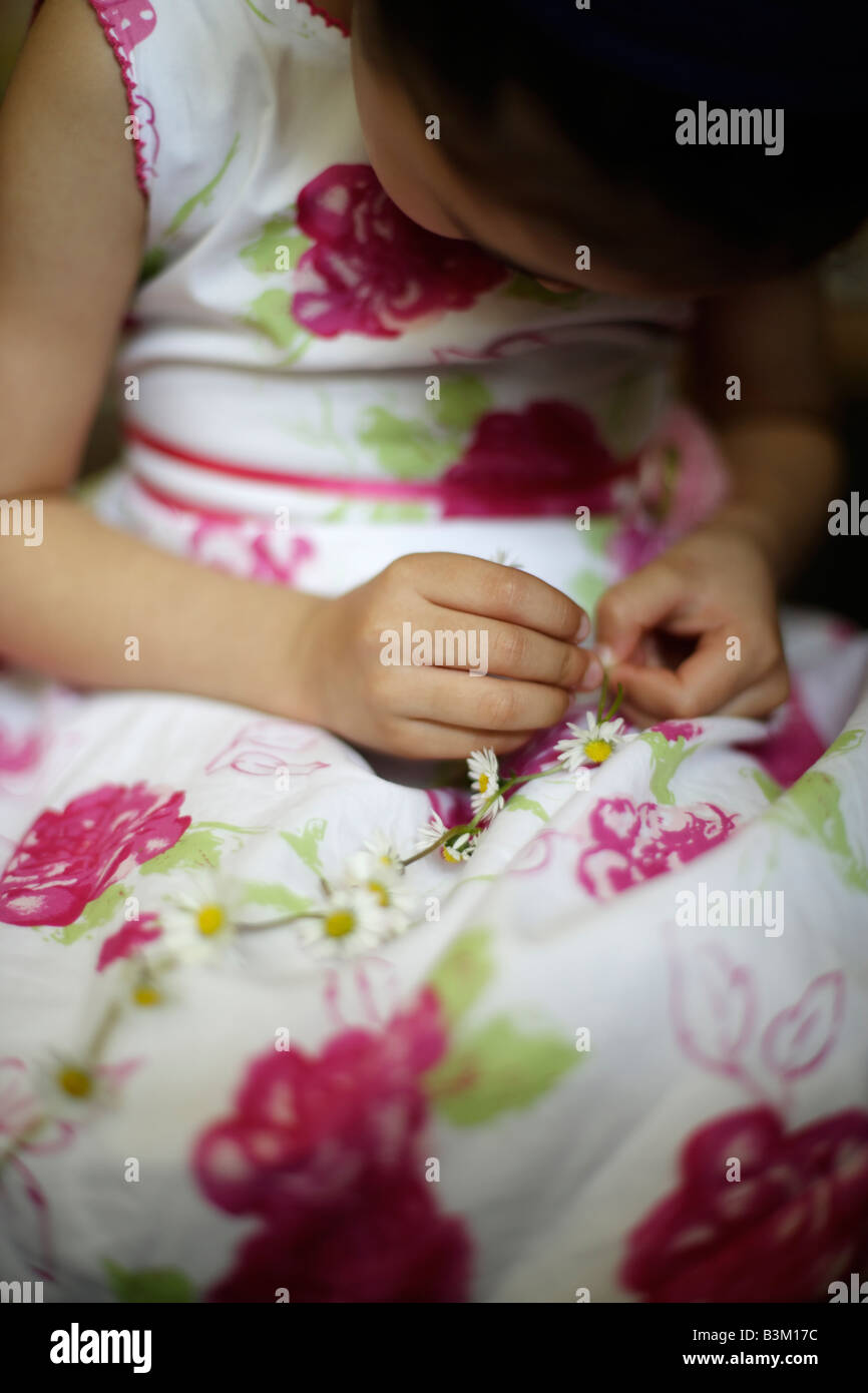 Fünf Jahre altes Mädchen macht Daisy-chain Stockfoto