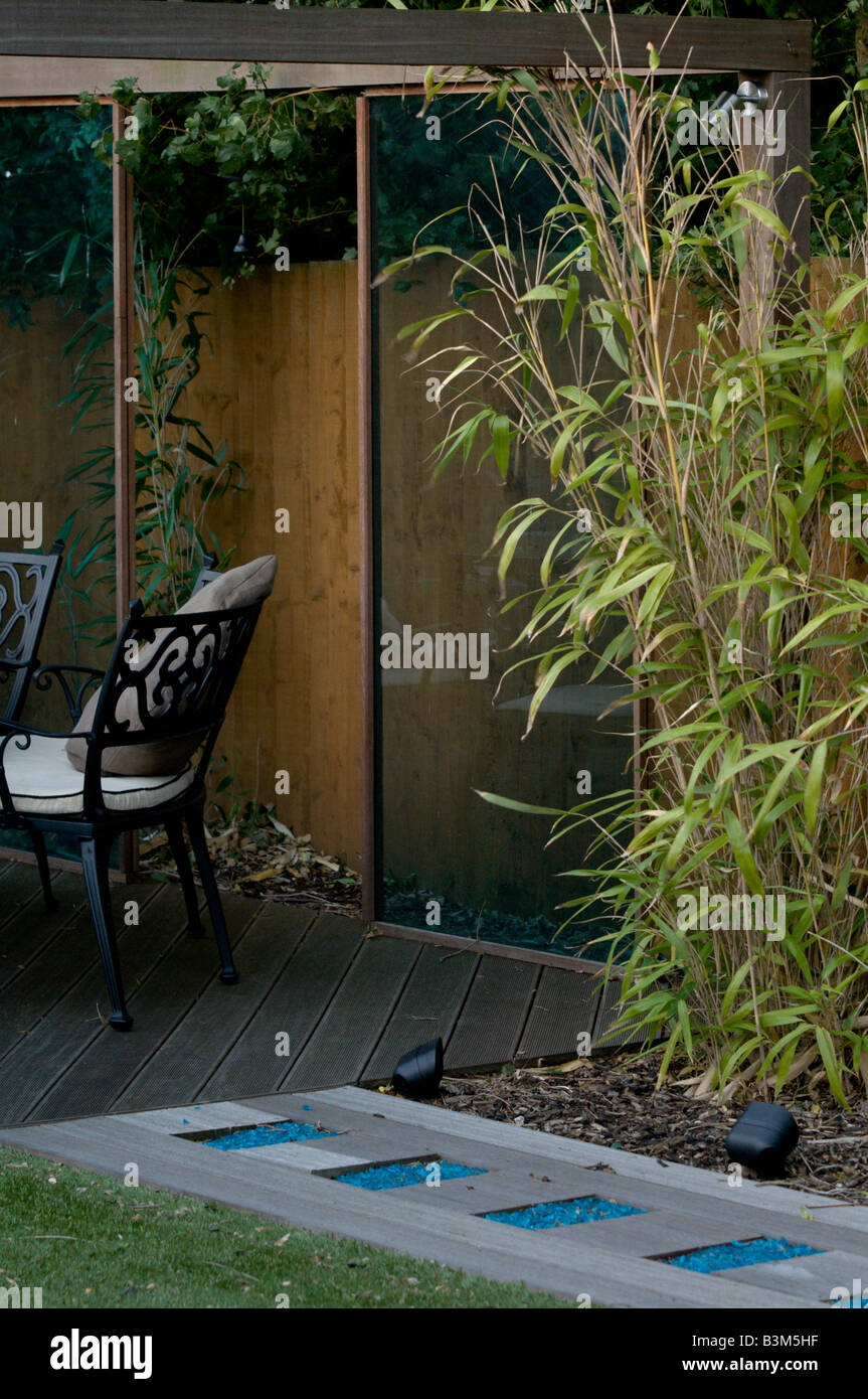 Decking Weg mit blauem Glas Leuchten führt zu Pavillon mit Tisch und Stühlen Stockfoto