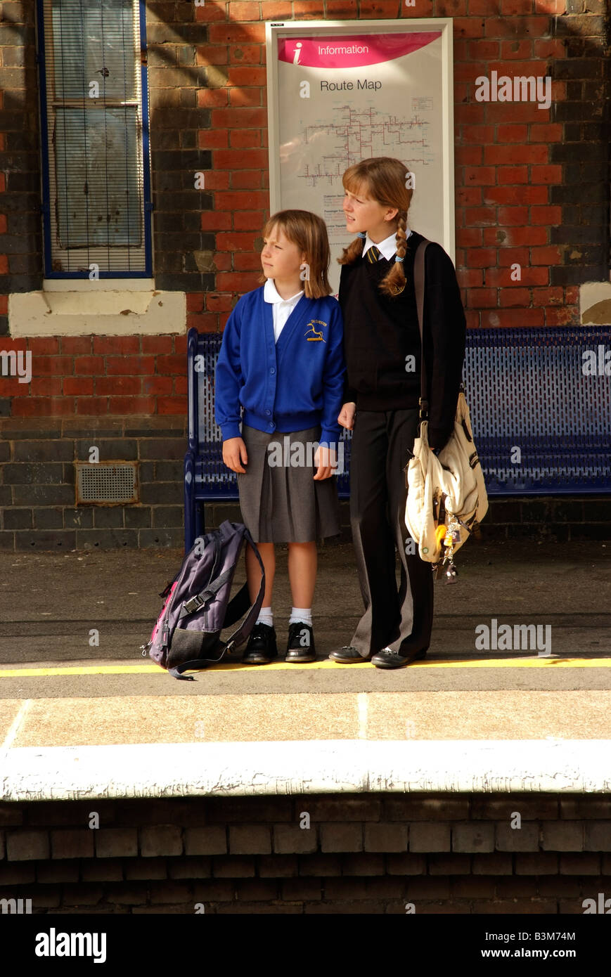 Junge Mädchen warten auf eine Bahn Bahnhof Plattform Reisen von und nach der Schule Stockfoto