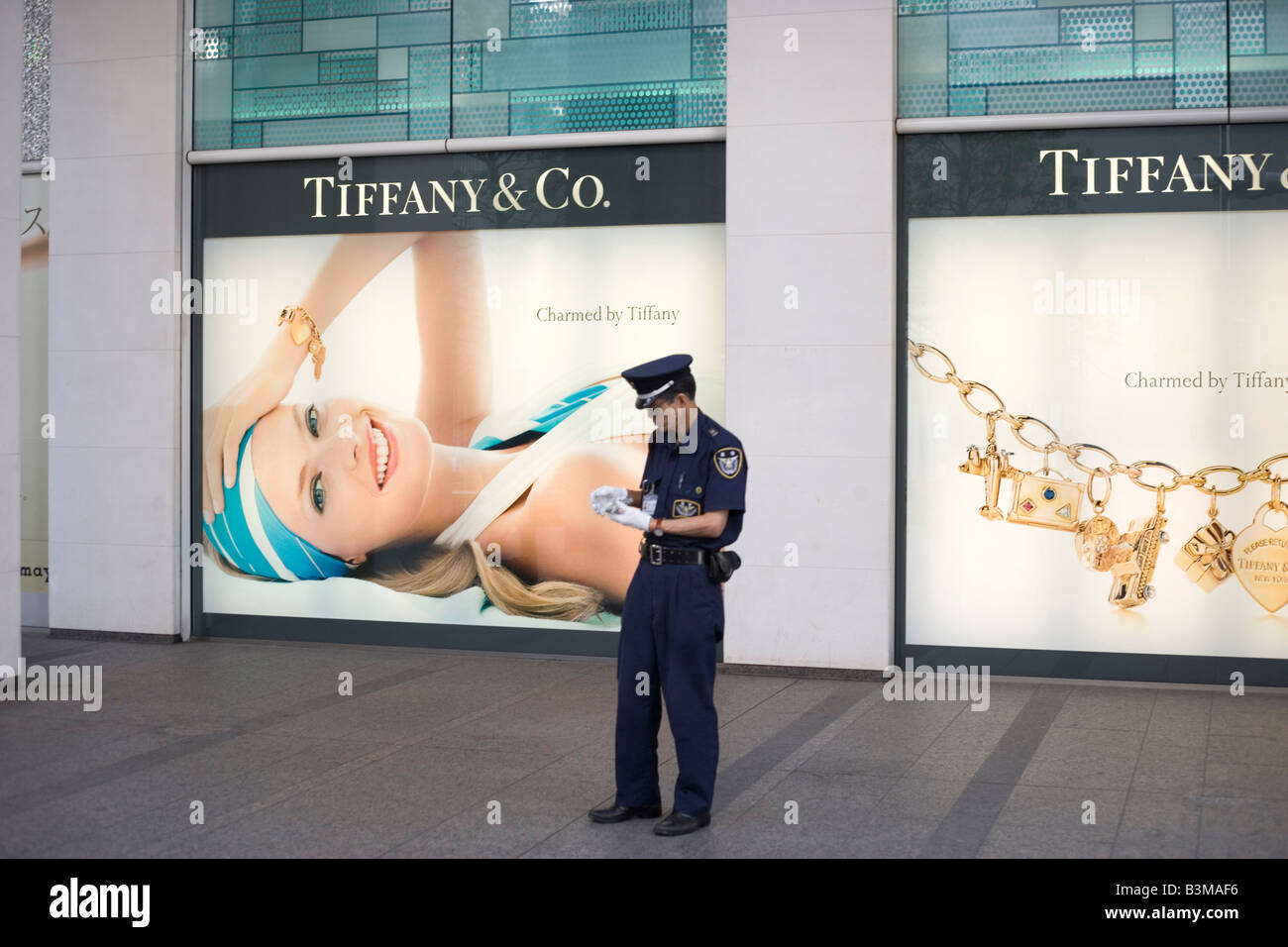Japanische Wachmann, Polizist, Stand an der Tokyo Street vor großen Mode-Werbung-Anzeige Stockfoto