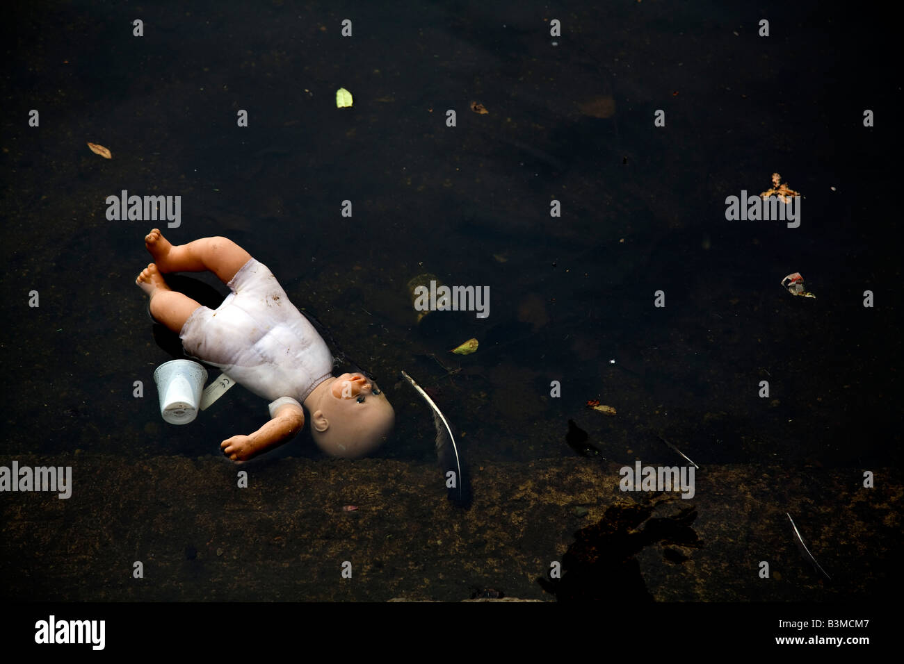 Kinder-Puppe in Wasser mit Müll entsorgt Stockfoto