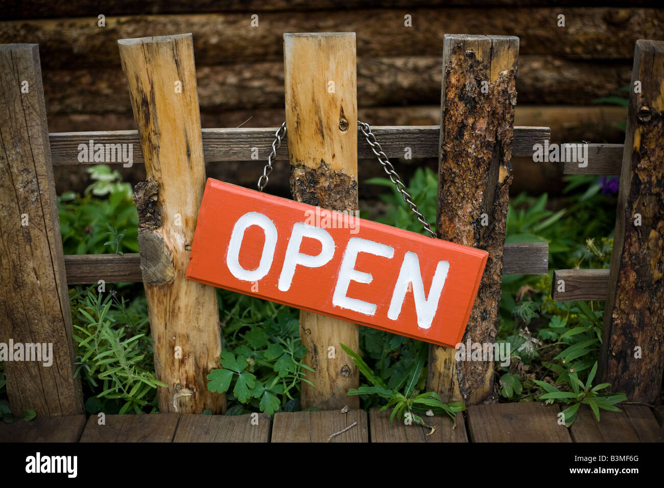 Orange und weiß 'Öffnen' Zeichen hängen von einer kleine, handgefertigte, hölzerne Zaunpfahl außerhalb eines Ladens in einer kleinen Stadt in Colorado. Stockfoto