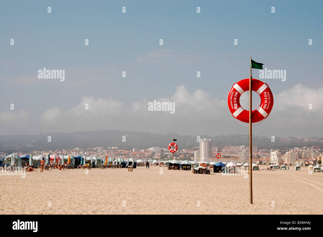 Strandzelte und Sandstrand von Figueira da Foz, Portugal, mit das Stadtbild im Hintergrund Stockfoto