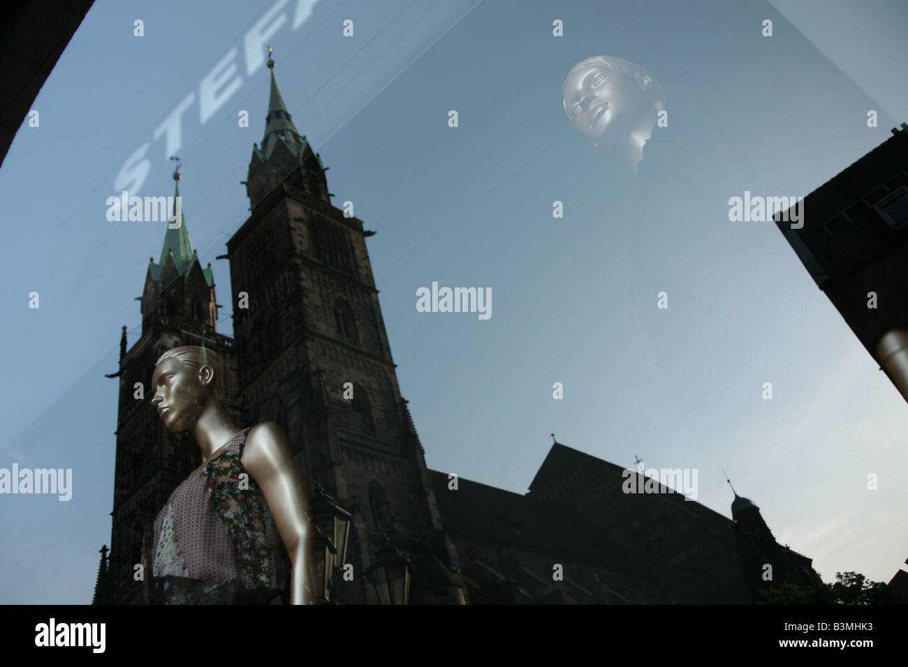 Mode-Schaufenster mit einer Reflexion der St.-Lorenz-Kirche in Nürnberg Stockfoto