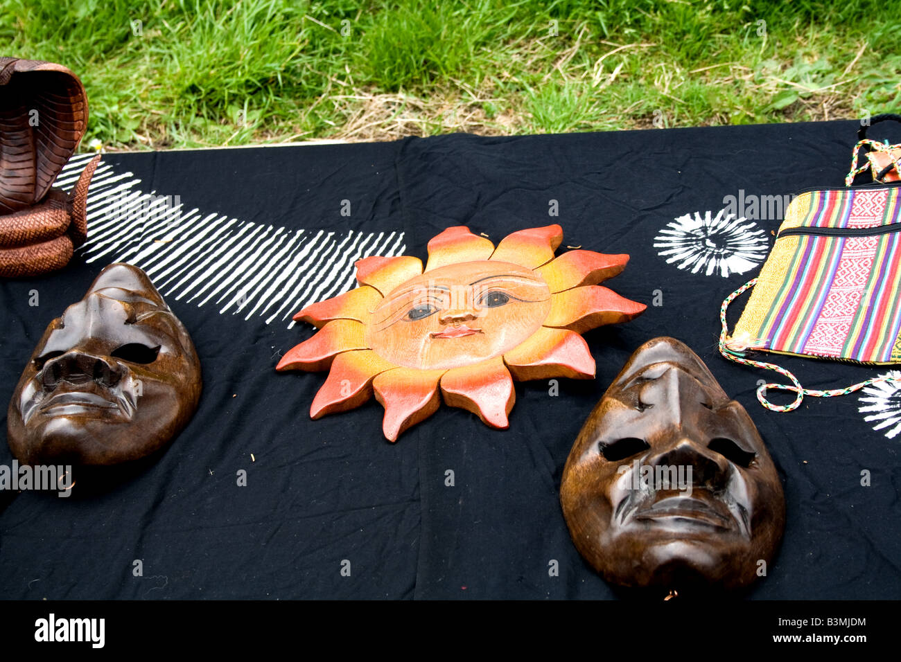 Zwei hölzerne Gesicht Masken mit einer hölzernen künstlerische Darstellung der Sonne ich Stockfoto