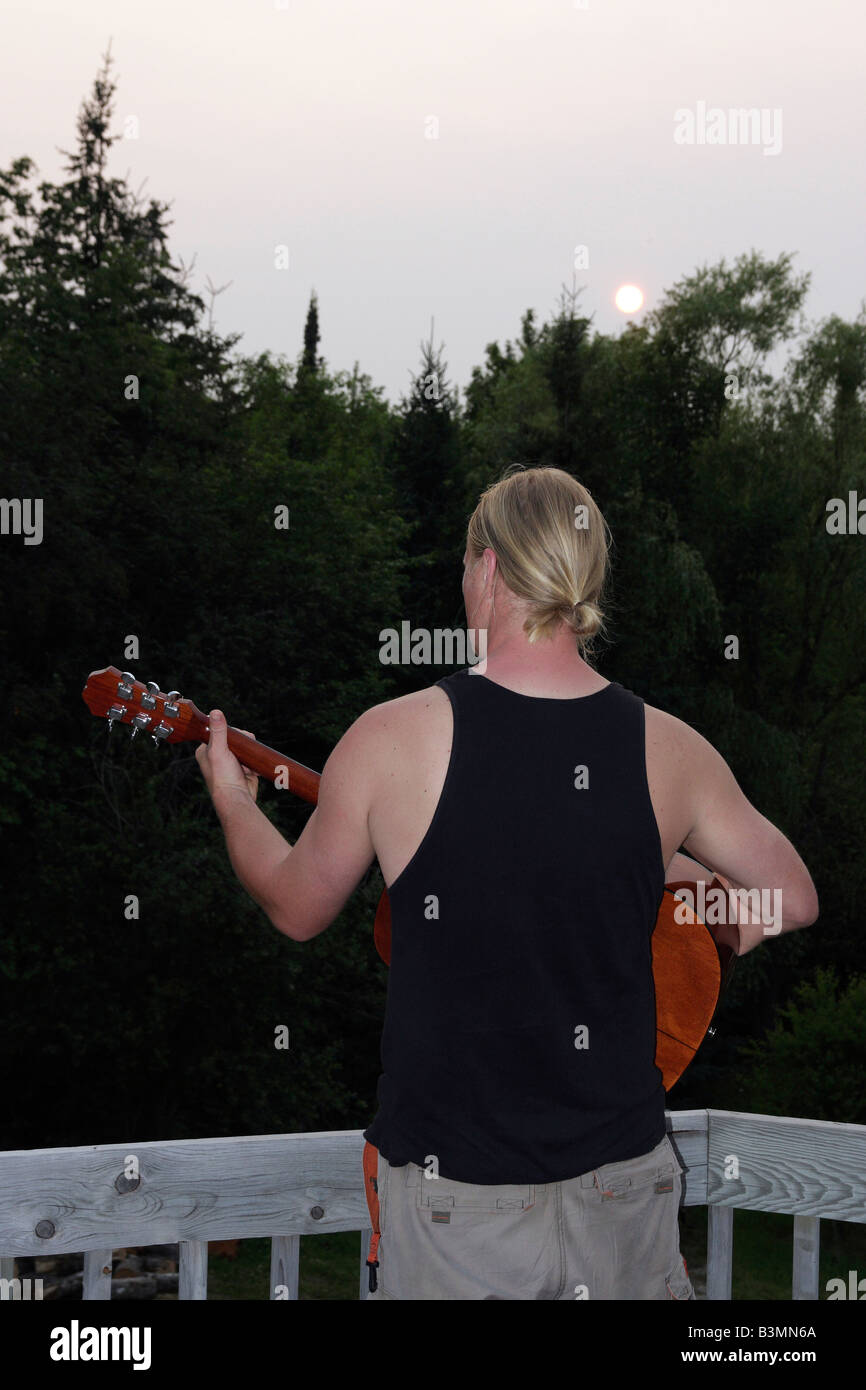 Blondes Haar auf der Gitarre in Michigan MI USA Blick von hinten auf die szenische Person Sommer Saison vertikale Hi-res Stockfoto