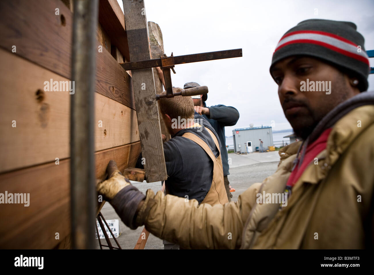Ein Team von drei Leuten arbeitet an der alten Segelboot Merrie Ellen auf der Werft von Port Townsend Stockfoto