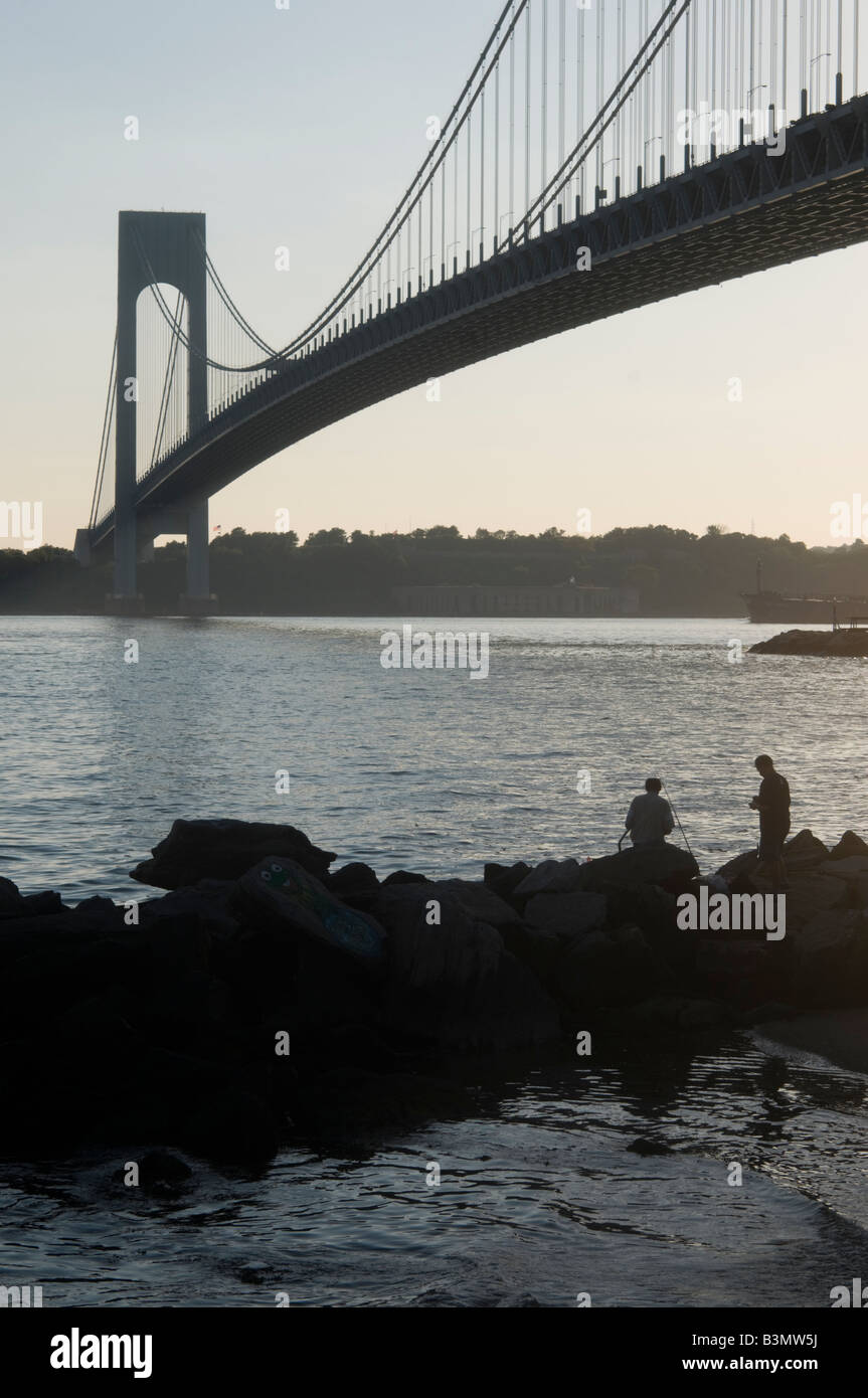 Zwei Männer Fische aus einem Riff auf der Brooklyn-Seite von Verrazano Bridge Staten Island am Horizont Stockfoto