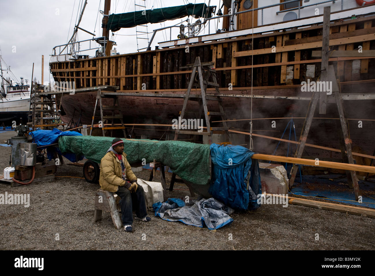 Ein Team von drei Leuten arbeitet an der alten Segelboot Merrie Ellen auf der Werft von Port Townsend Stockfoto
