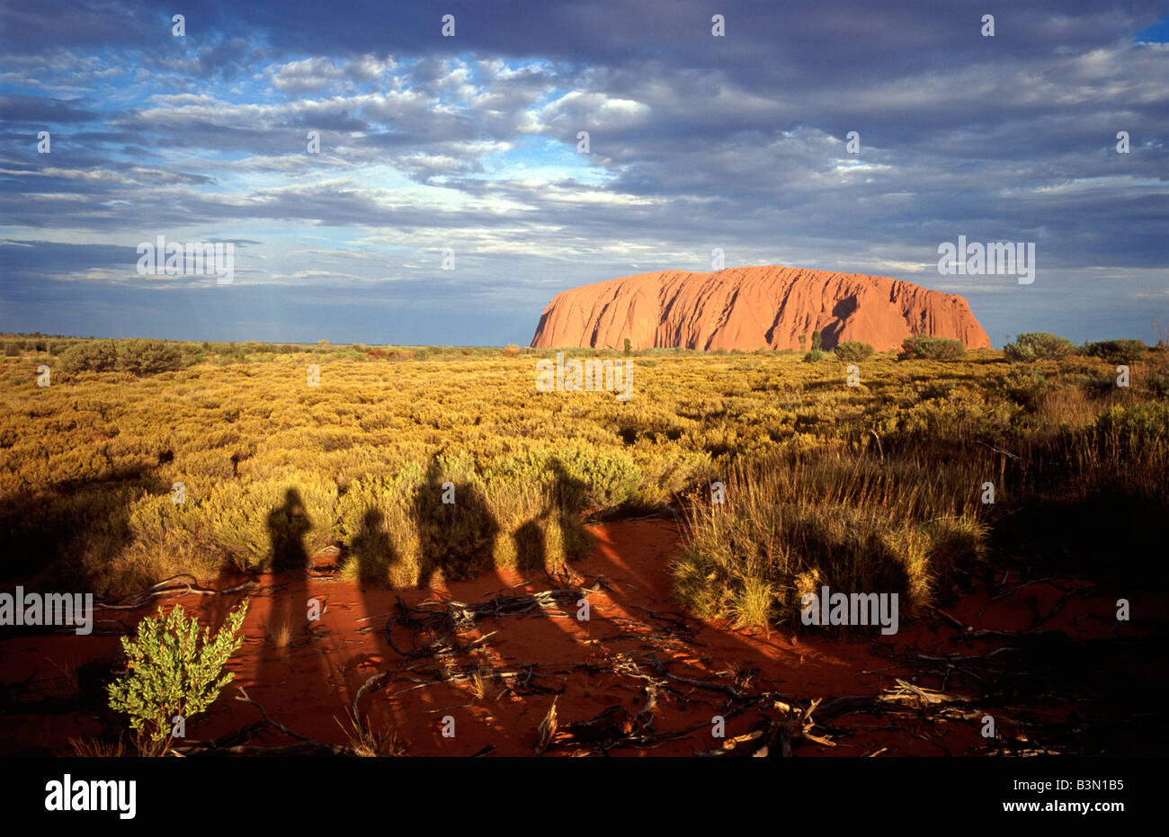 Die Schatten der Touristen beobachten den Sonnenuntergang am Uluru, sonst bekannt als Ayers Rock in Australien Stockfoto