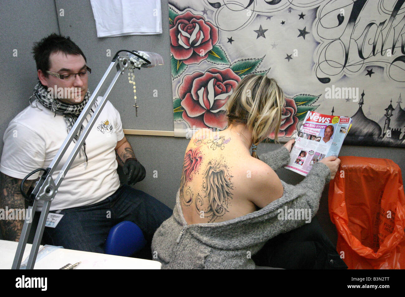 Frau, die eine Tätowierung getan auf London Tattoo convention Stockfoto